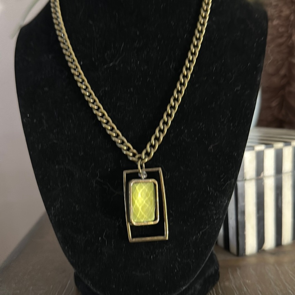 Vintage brass chain with square pendent with green glass bead inside it turns
